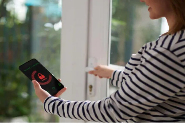 A woman with a cellphone app that shows a lock icon